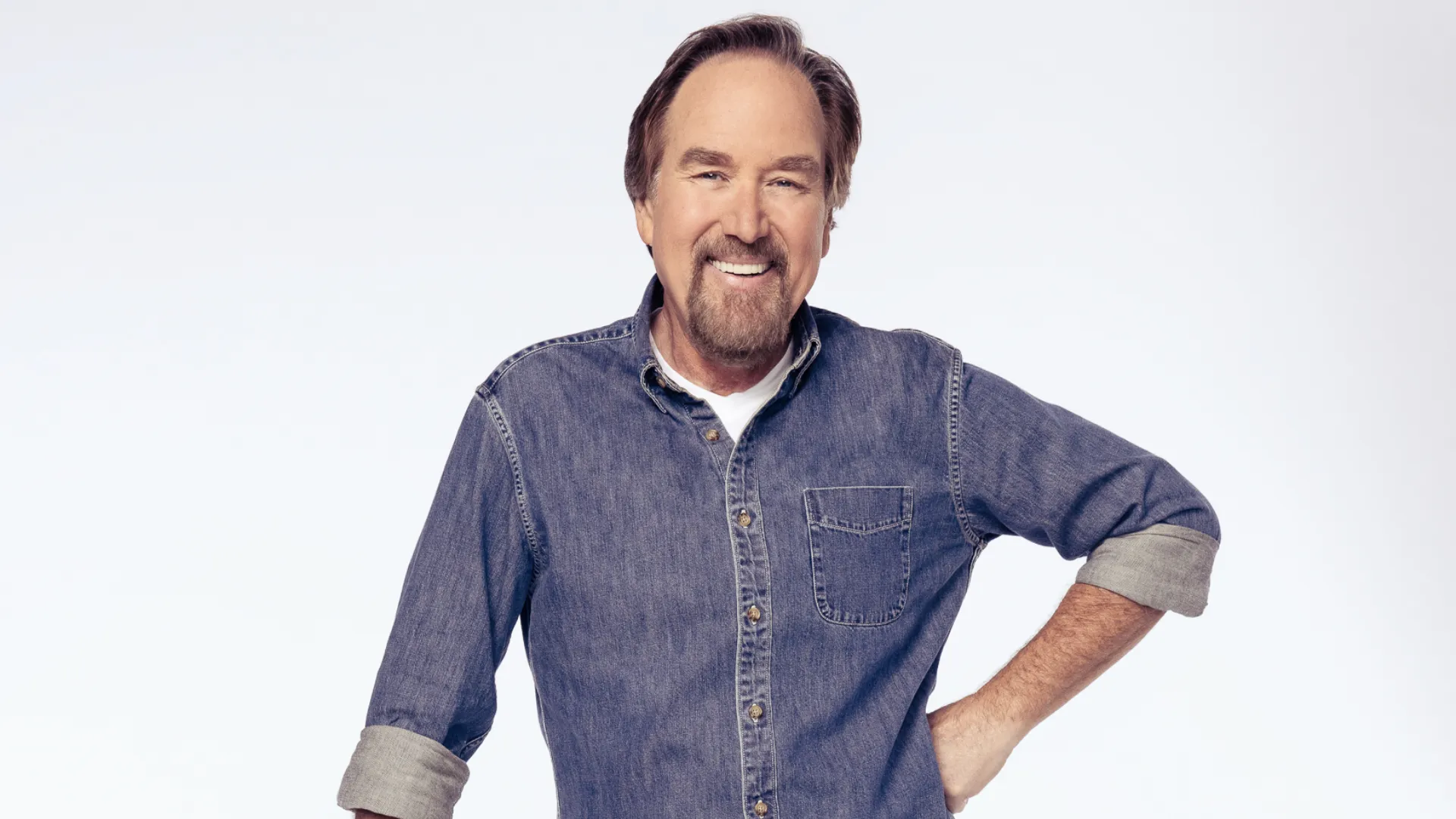 Richard Karn Net Worth professional portrait in denim shirt with casual smile on white background.